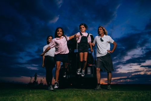 Free A happy family with kids having fun near a golf cart at sunset. Stock Photo