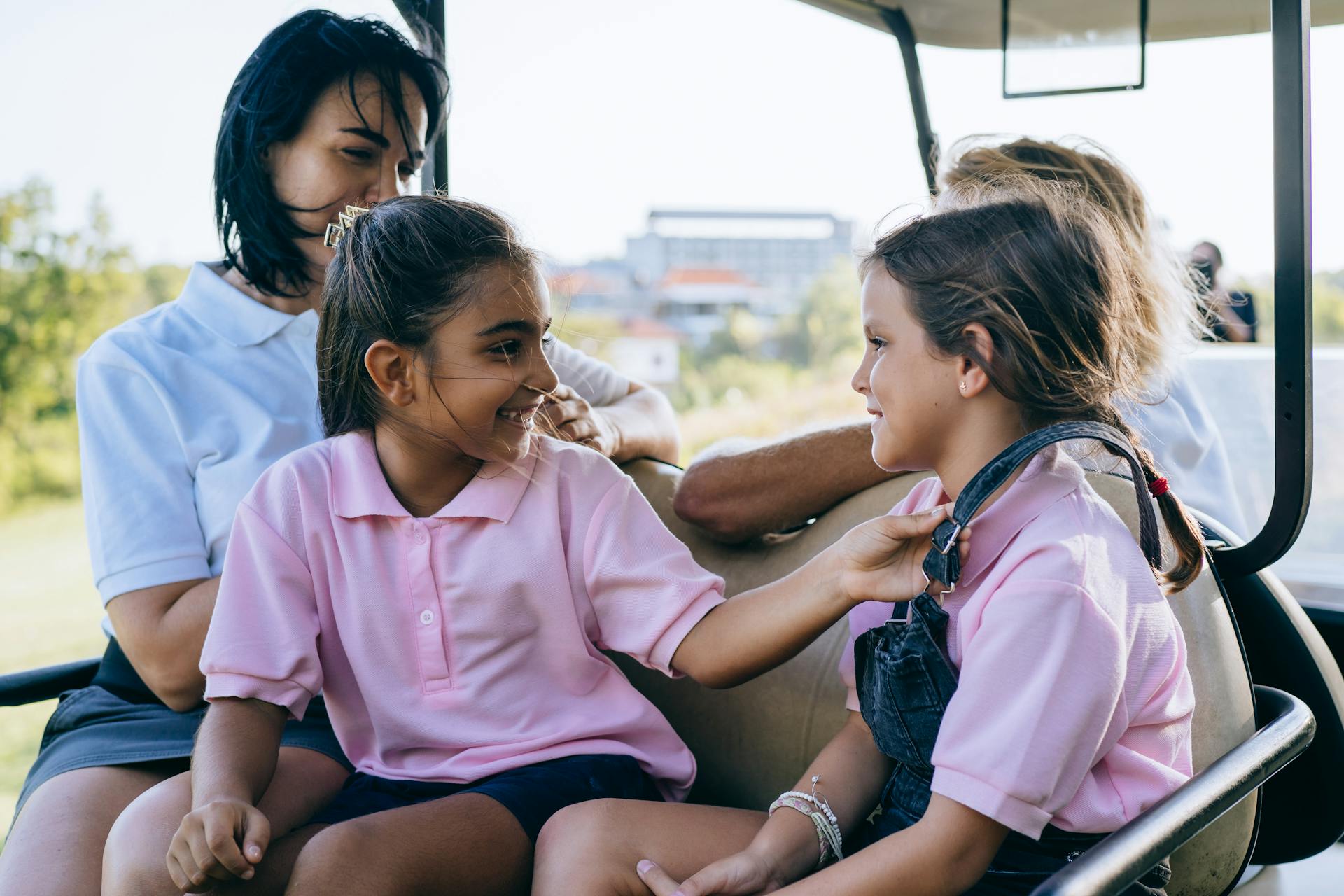 Family bonding during a leisurely golf cart ride on a sunny day.
