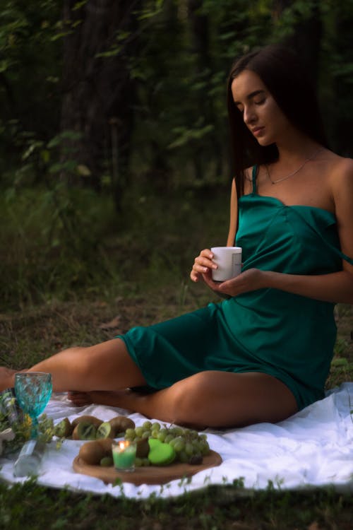 Woman in Green Spaghetti Dress holding a Candle 
