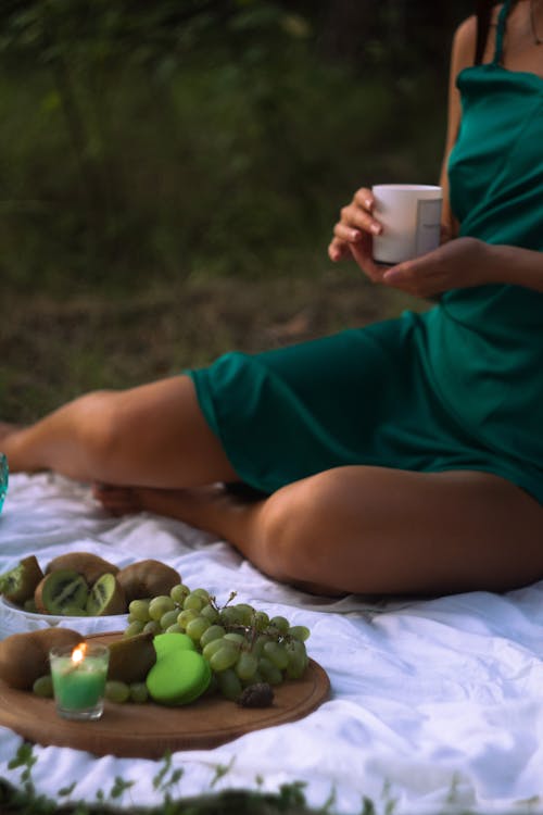 Woman in Green Spaghetti Dress holding a Candle