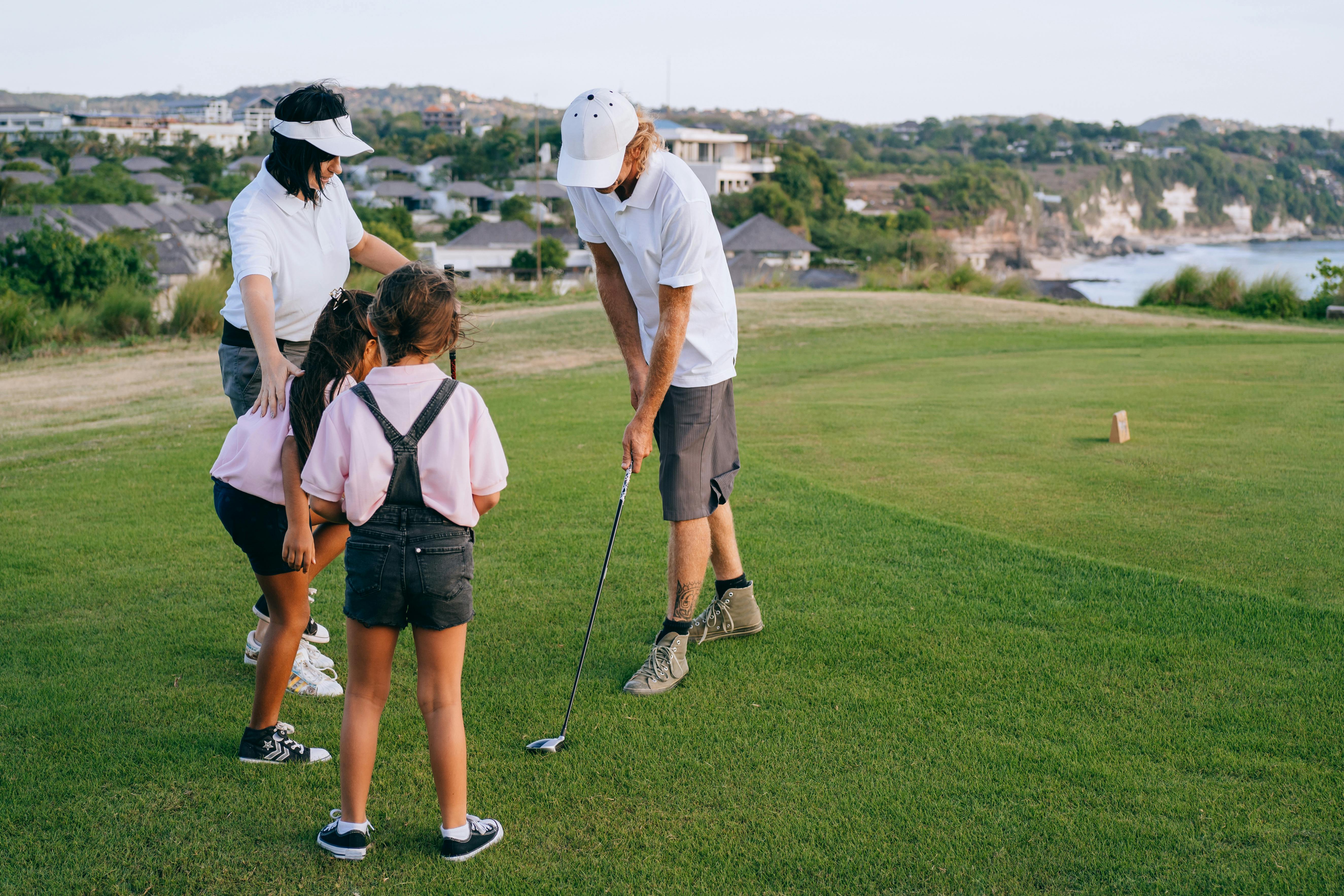 family playing golf on green grass field