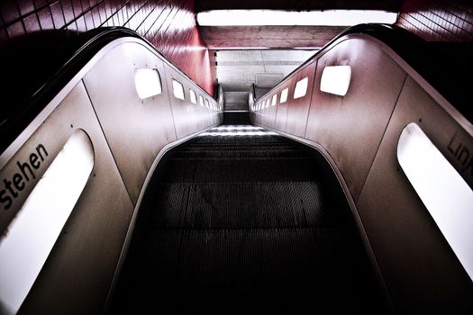 城市地铁站内自动扶梯下降的视角展现了现代建筑