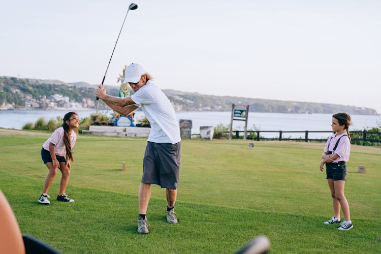 Man Playing Golf Together With His Children