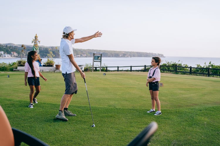 Father And Daughters Playing Golf