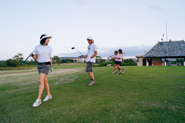 Family Carrying Golf Clubs While Walking