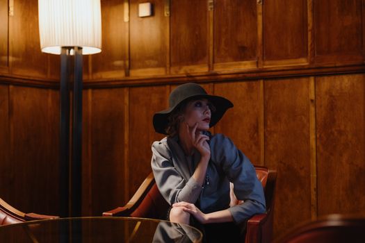 Woman in Wide-brimmed Hat Sitting in Brown Wooden Chair