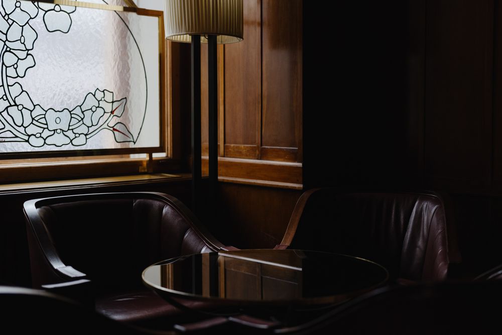 Dark leather barber chairs in a wood-panelled room