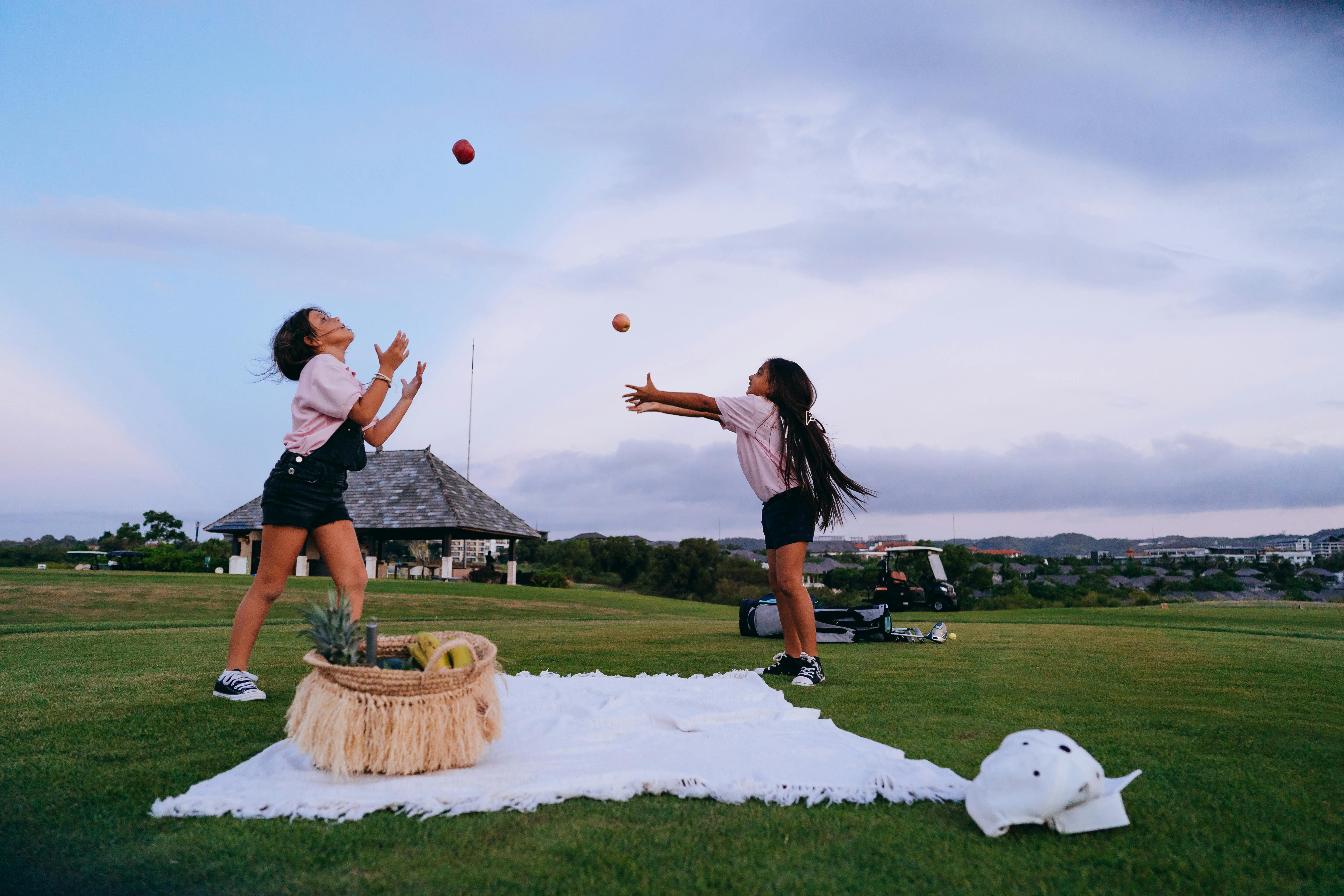 Woman in Black Shirt and Black Shorts Playing Basketball on Green Grass Field