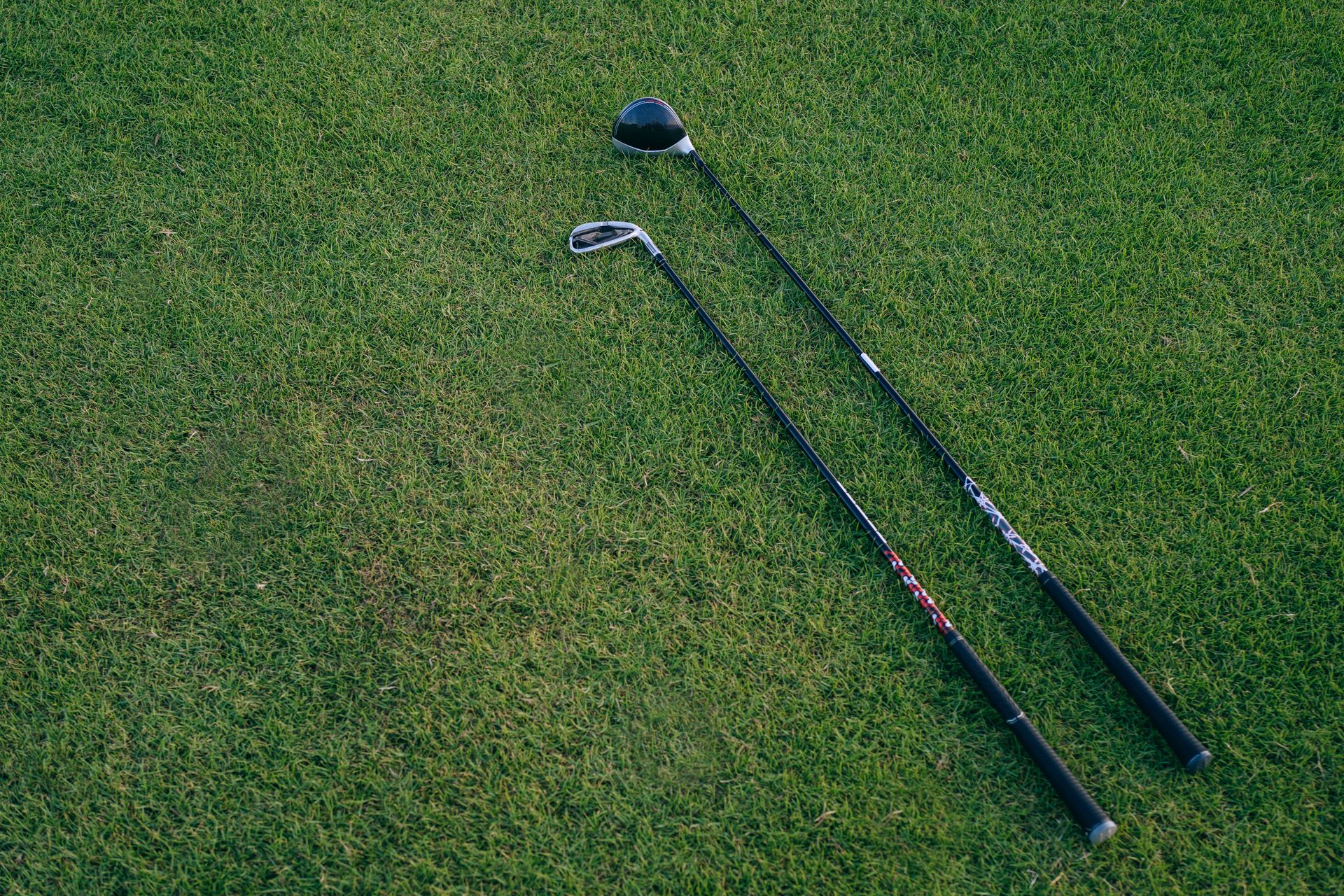 Two golf clubs resting on a manicured fairway