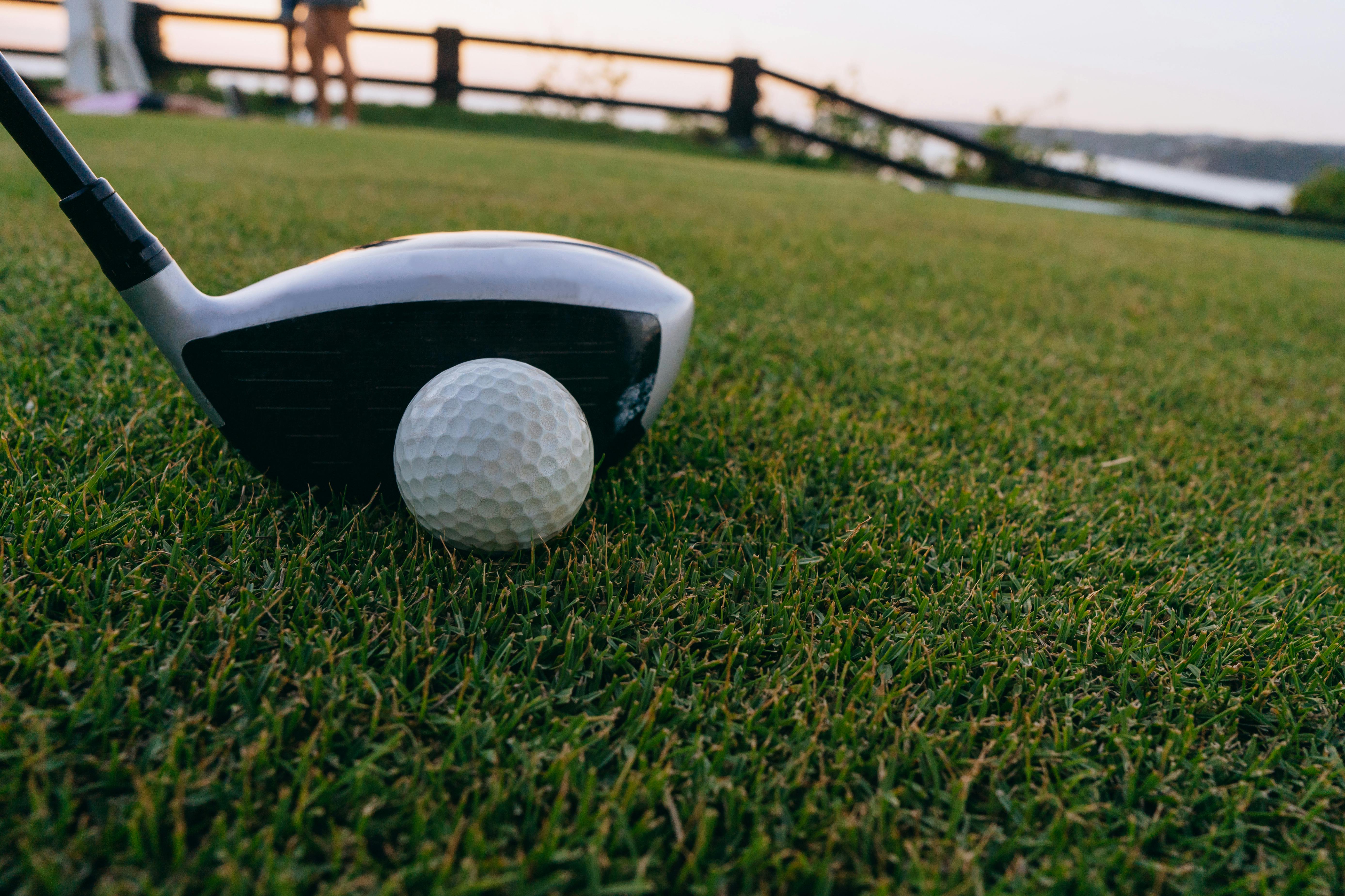 a close up shot of a golf ball and a golf club