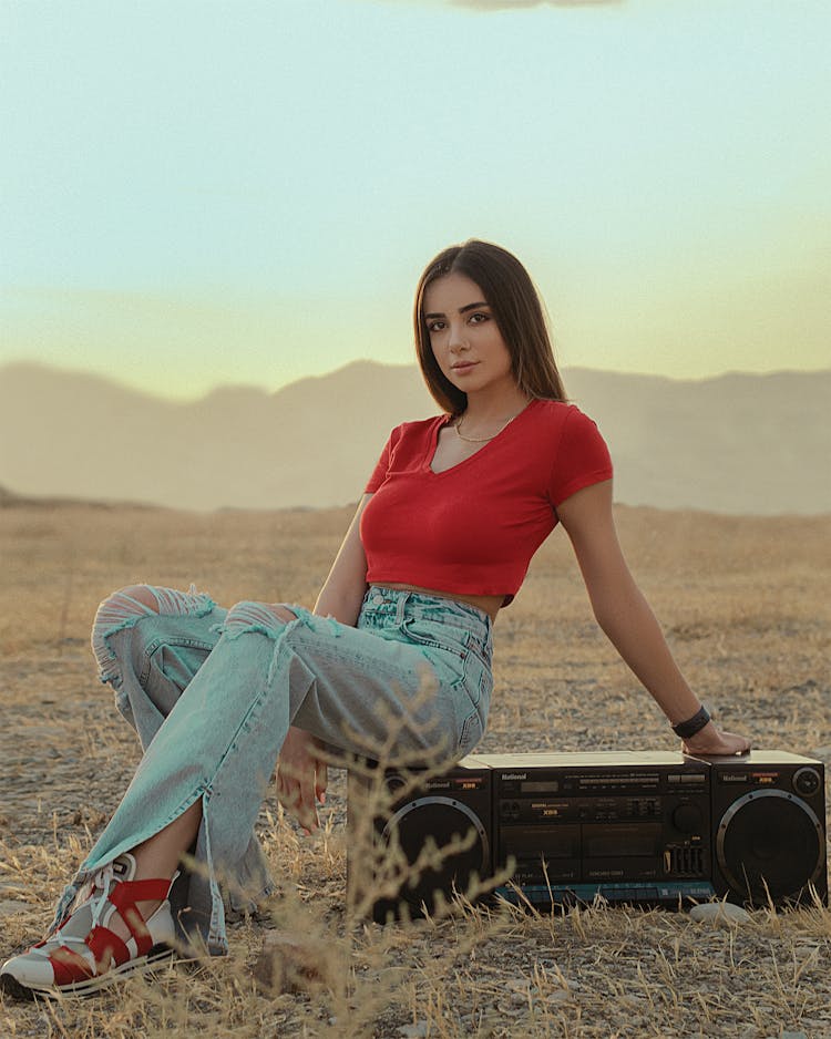 Woman Wearing Red Shirt Sitting On A Vintage Stereo