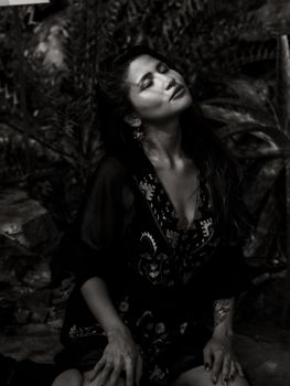 Captivating monochrome image of a woman in a serene pose, outdoors.