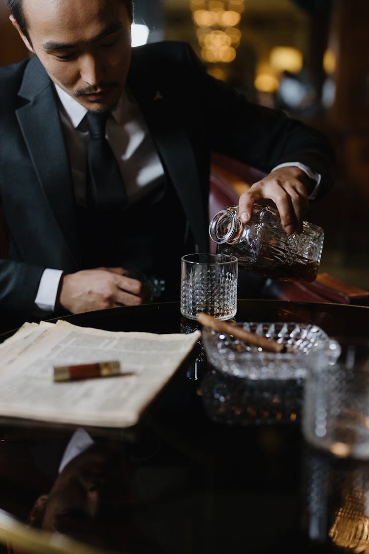 Man In Black Suit Pouring Drink On Glass 