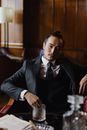 Man in Black Suit Sitting on Brown Wooden Chair