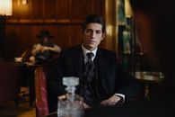 Man in Black Suit Sitting on Red Leather Chair