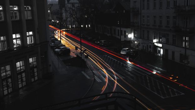 Urban night scene showcasing fast-moving cars creating vivid light streaks on city streets.