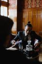 Woman in Black Blazer Sitting by the Table