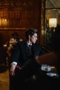 Man in Black Suit Jacket Sitting on Chair