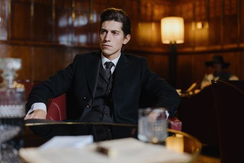 Free Man in a black formal suit sitting in a vintage room, exuding sophistication and elegance. Stock Photo