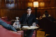 Man in Black Suit Sitting on Chair in Front of Table