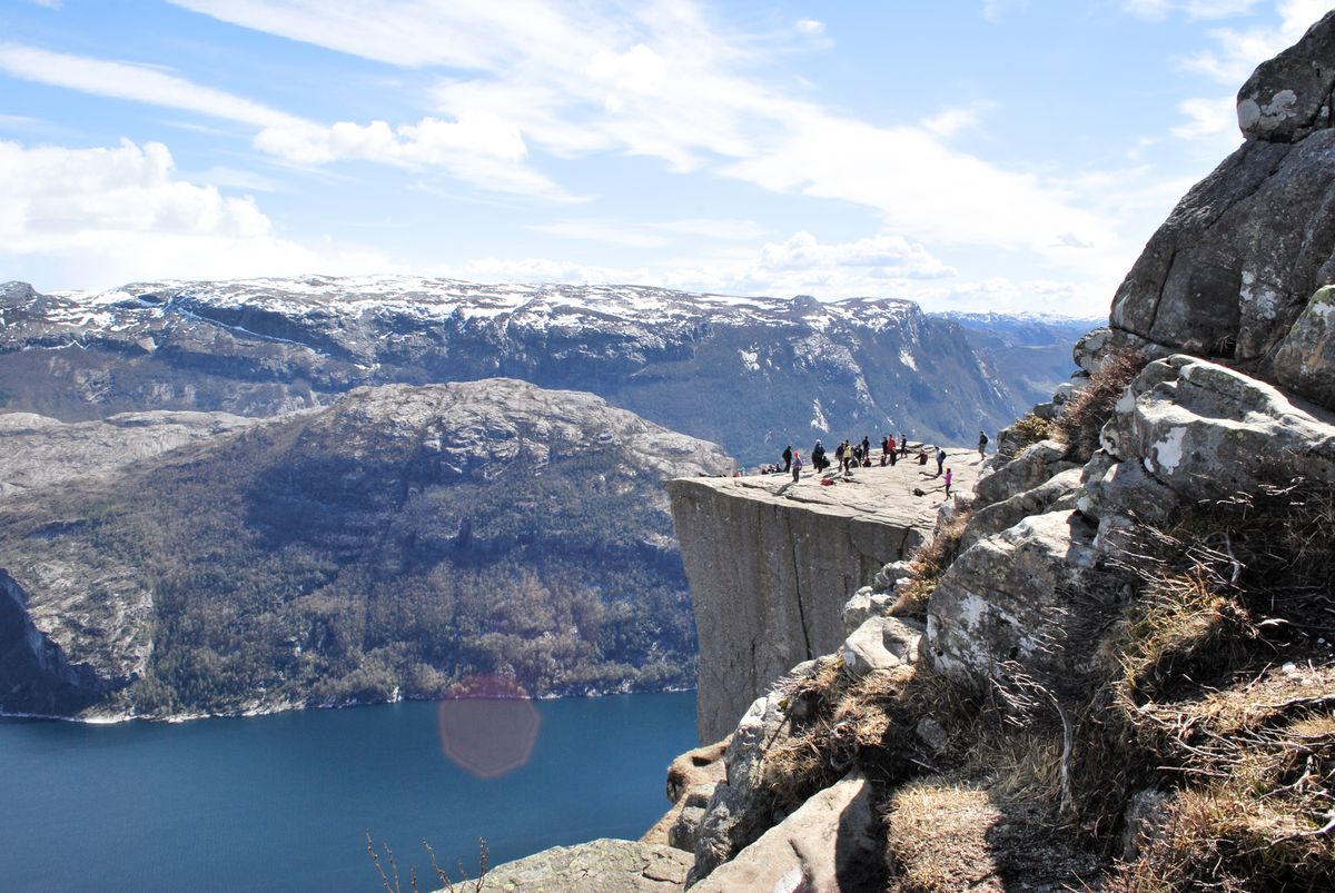 Tourists enjoying the view from the famous Preikestolen cliff overlooking the Lysefjord in Norway