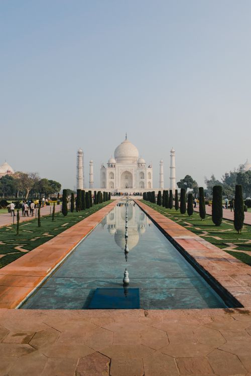 Free The iconic Taj Mahal reflecting in tranquil pool under clear sky. Perfect symbol of Mughal architecture. Stock Photo