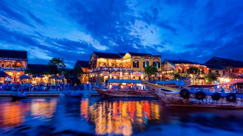 Free Enchanting view of Hội An's riverside with colorful lights reflecting on water at night. Stock Photo