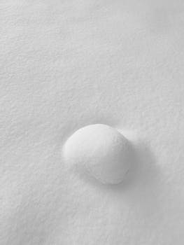 Minimalist winter scene of fresh snow with a small mound in Kingiseppsky District, Russia.