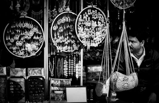 Elegantly arranged jewelry and accessories displayed at a street market in black and white.
