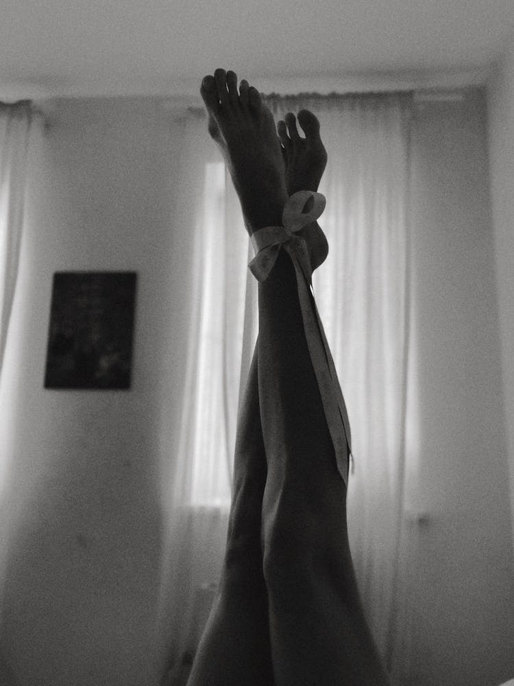 
A Grayscale Of A Feet Tied Together