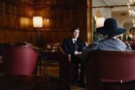Man in Black Suit Sitting on Brown Wooden Chair