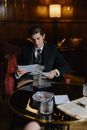 Man in Black Suit Jacket Sitting on Chair