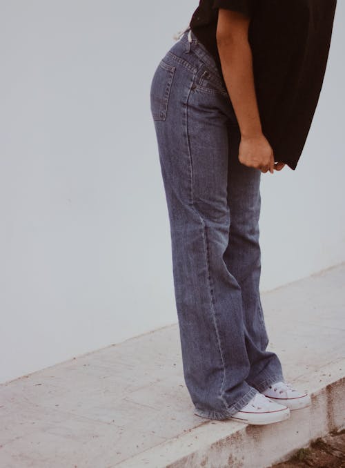 Free A Person in Denim Jeans Standing on a Curb Stock Photo