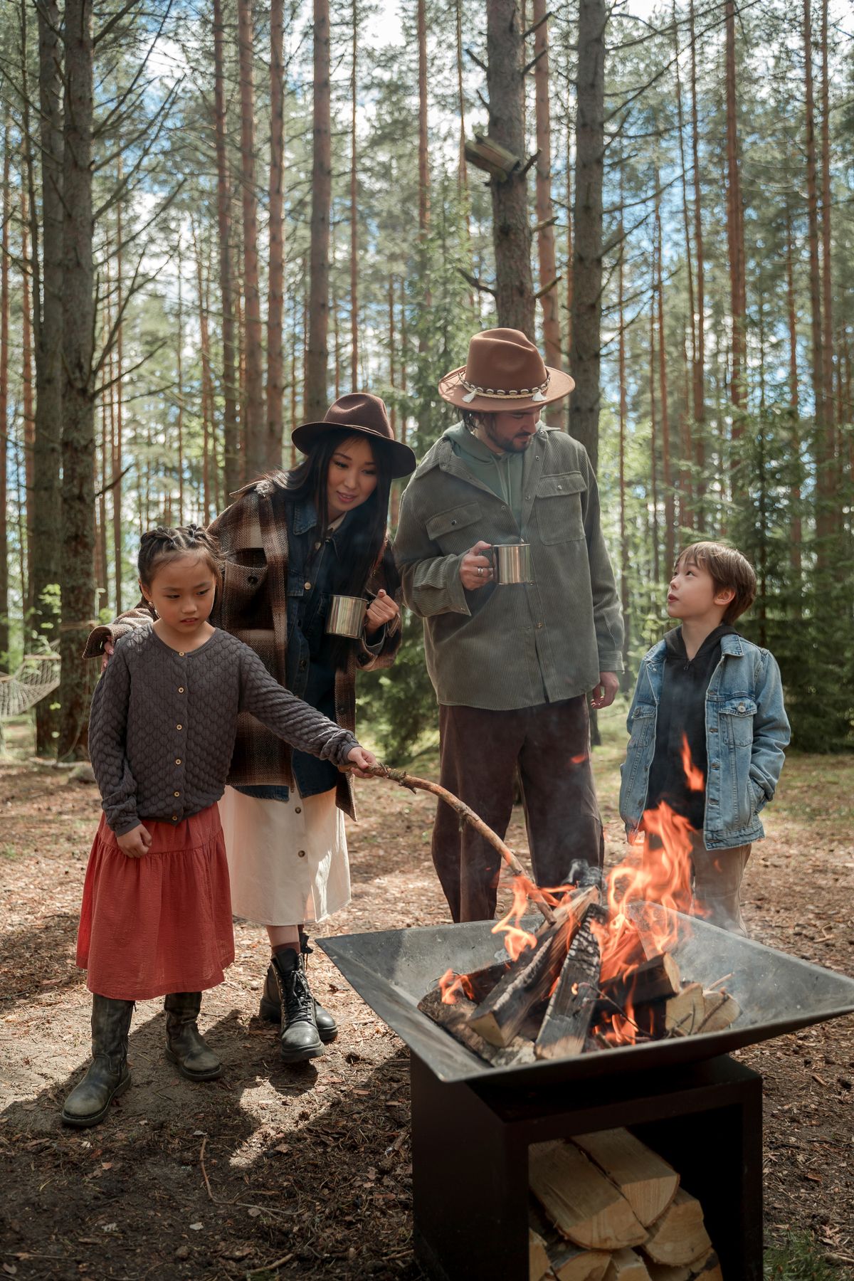 Family bonding around a campfire at a woodland campsite; temporary illustrative stock photograph by Ron Lach