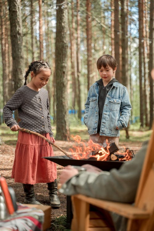 Siblings standing beside a Bonfire