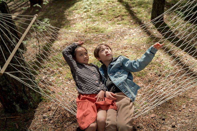 Girl And Boy Lying Down On Hammock