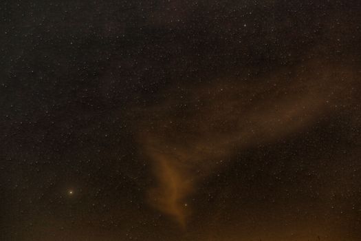 A mesmerizing view of a starry night sky with wispy clouds illuminated softly, perfect for backgrounds.