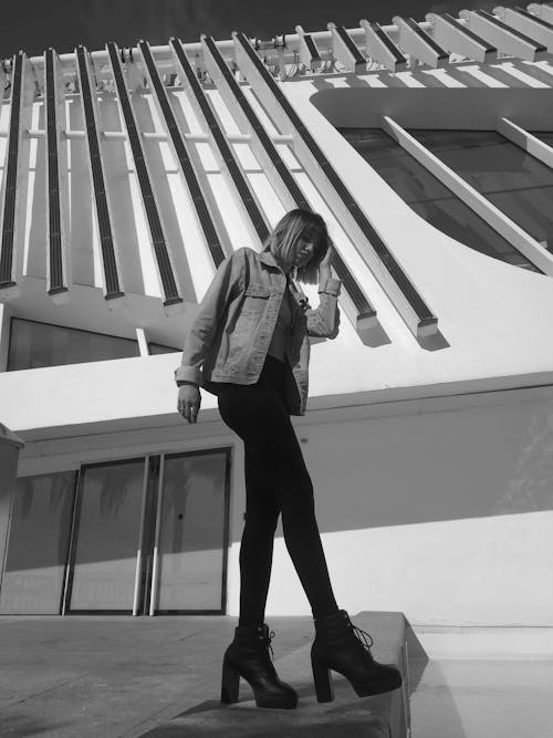 Woman Wearing a Jacket Standing Beside a Building