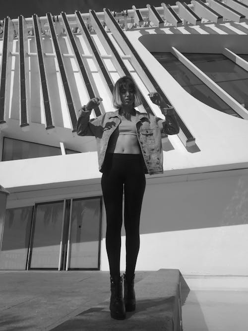 Free Woman Wearing Leggings Standing Beside a Building Stock Photo