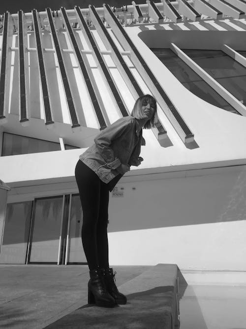 Black and White Photo of a Woman Posing outside a Building