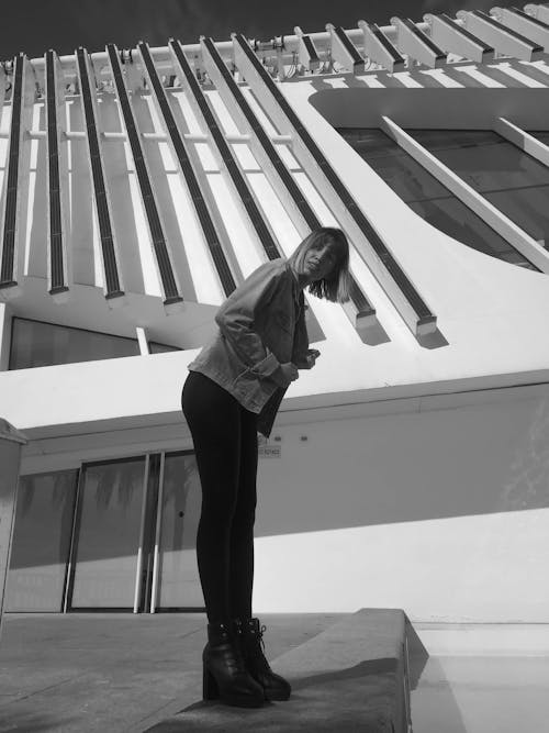 Free Grayscale Photo of a Woman Posing Outside a Building Stock Photo