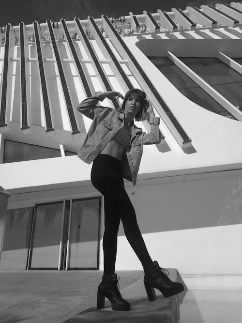Monochrome Photo of a Woman Posing Outside a Building