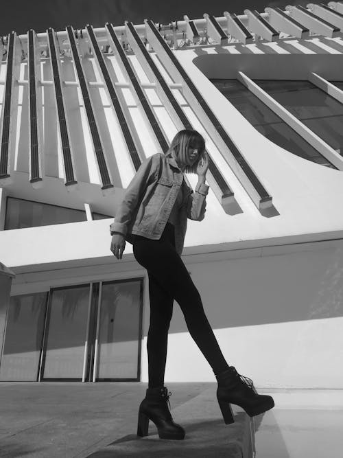 Free Woman in Black Jacket and Black Pants Standing on White Concrete Staircase Stock Photo