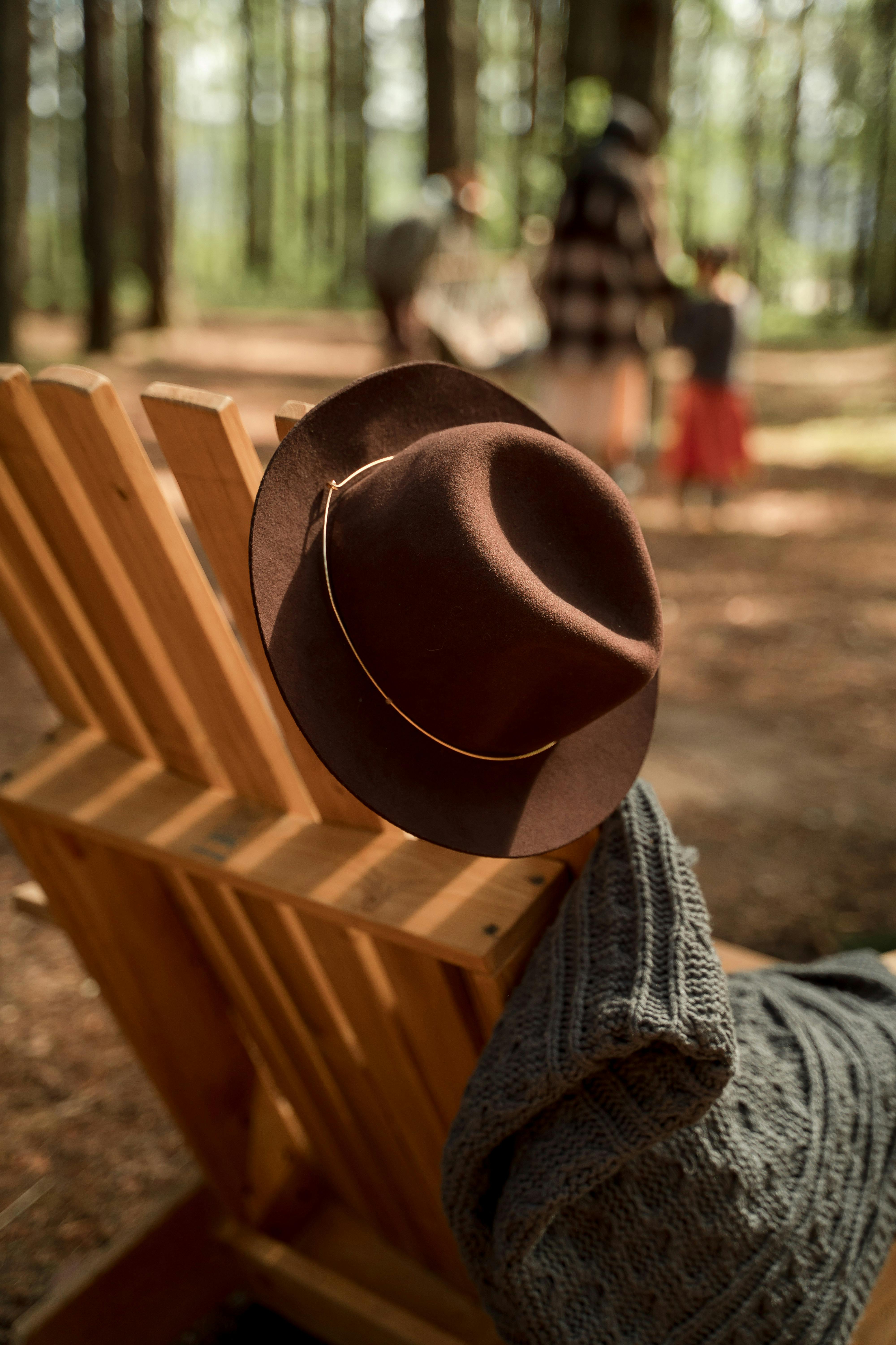 brown fedora hat on a wooden chair