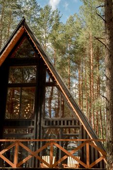 A charming A-frame cabin surrounded by dense forest trees, showcasing nature's beauty.