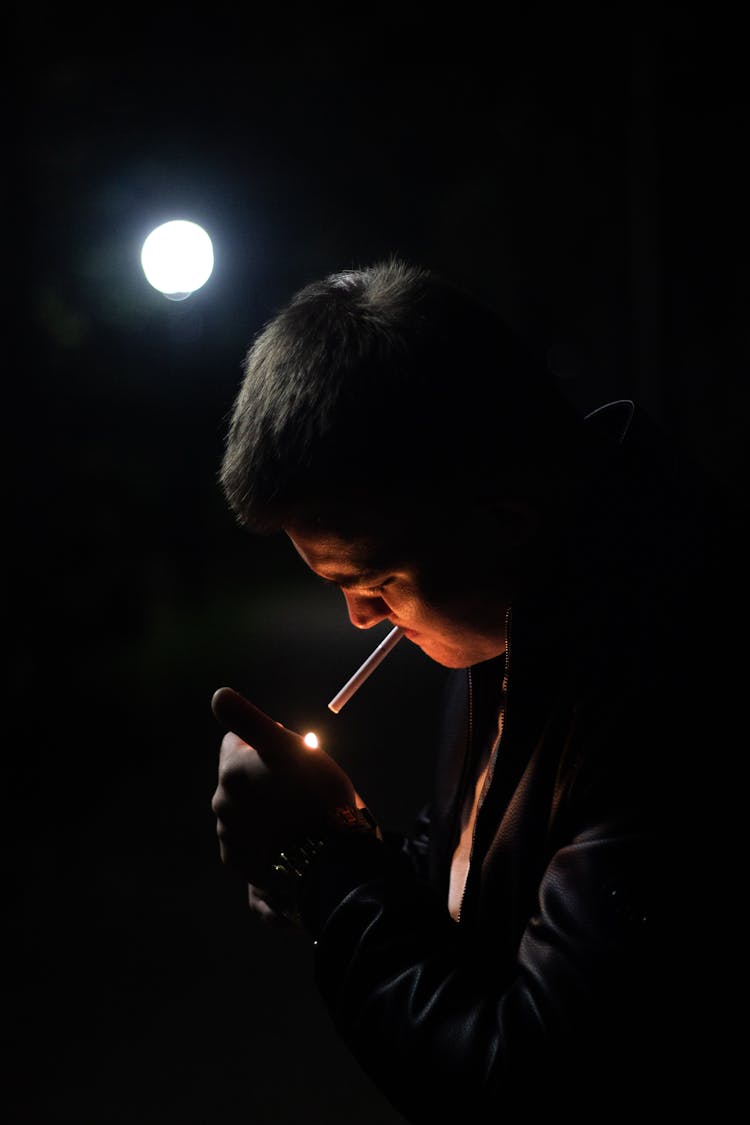 Man Lighting Cigarette In Dark