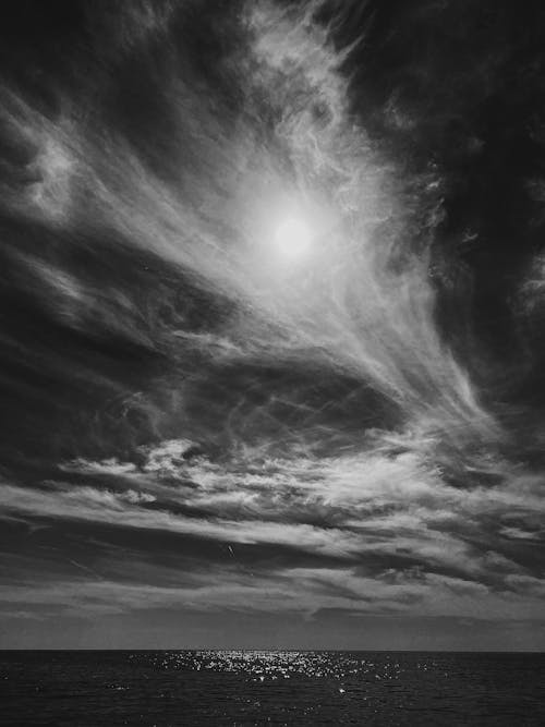 Grayscale Photo of Cloudy Sky over Sea