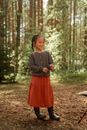 A Happy Girl Standing in the Woods while Holding a Stick