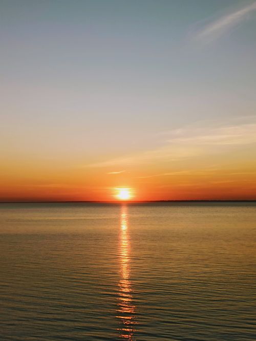 Free Beautiful sunset reflecting over the calm waters in Berdsk, Russia. Stock Photo