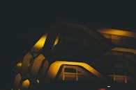 一座具有未来主义设计的现代照明建筑在夜间拍摄，呈现出戏剧性的灯光效果